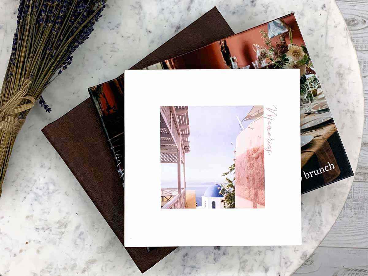 Stapel individueller Fotobücher auf einem Marmortisch.