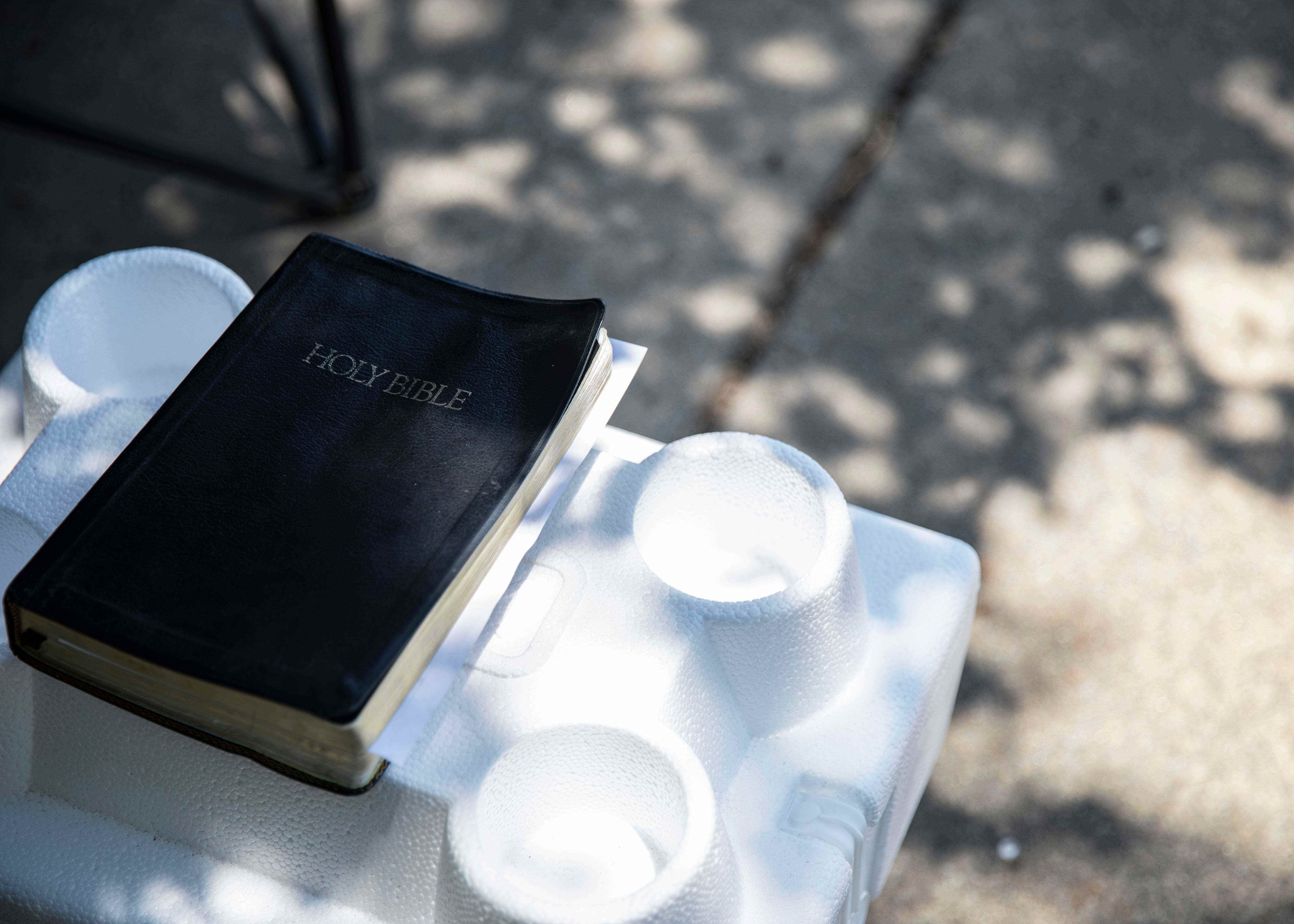 Eine Bibel ist auf einem Tisch auf einem Bürgersteig zu sehen.