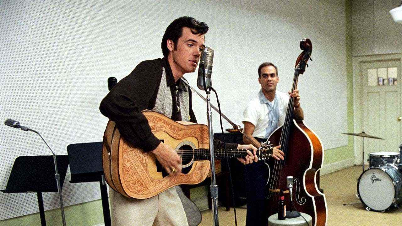 Tyler Hilton als Elvis Presley spielt Gitarre und singt in ein Mikrofon