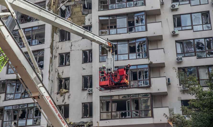 Feuerwehrleute versuchen, ein Feuer zu löschen, während Rauch aus einem Wohngebäude aufsteigt 