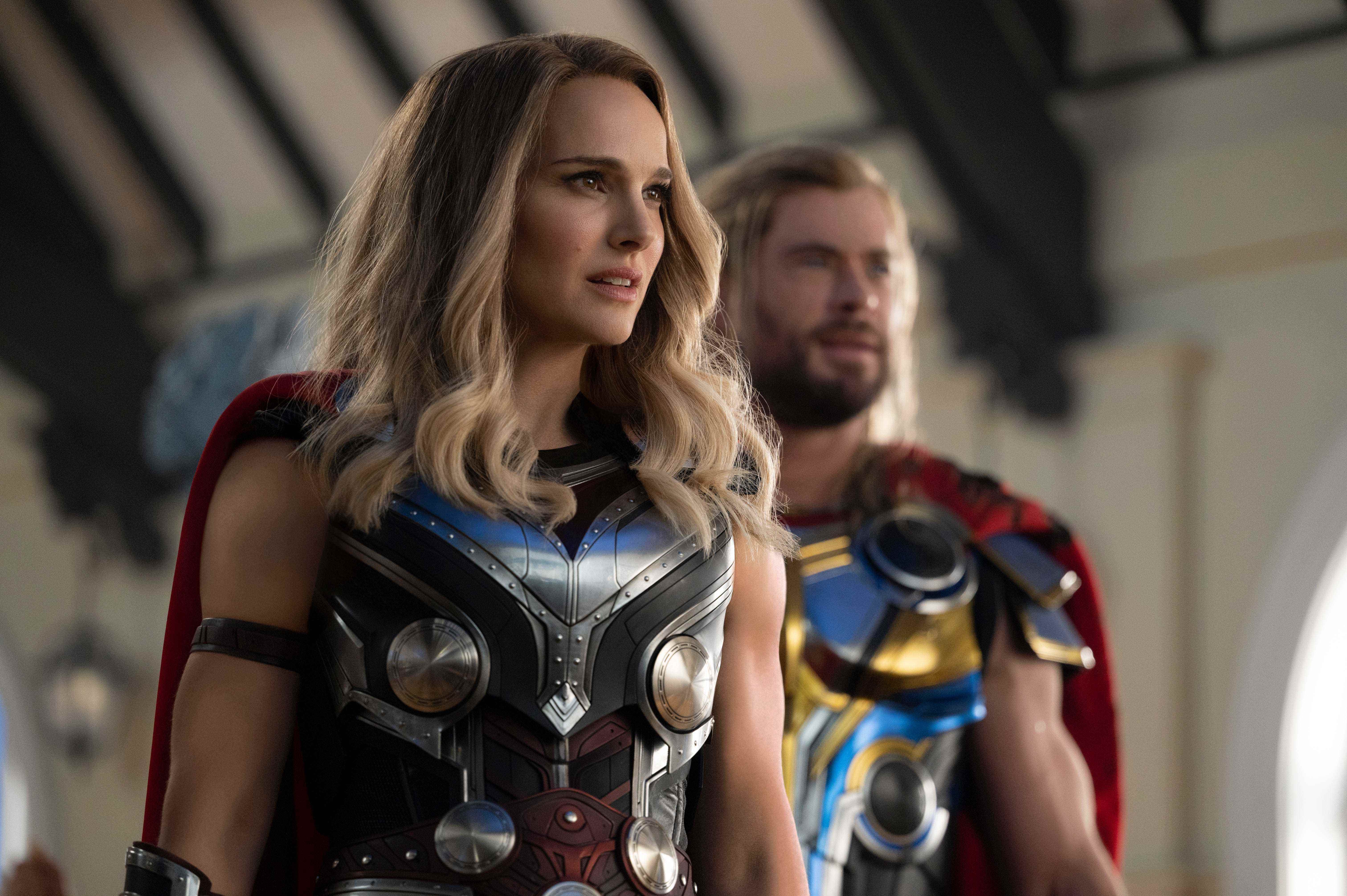 Natalie Portman steht vor Chris Hemsworth, beide tragen Thor-Kostüme
