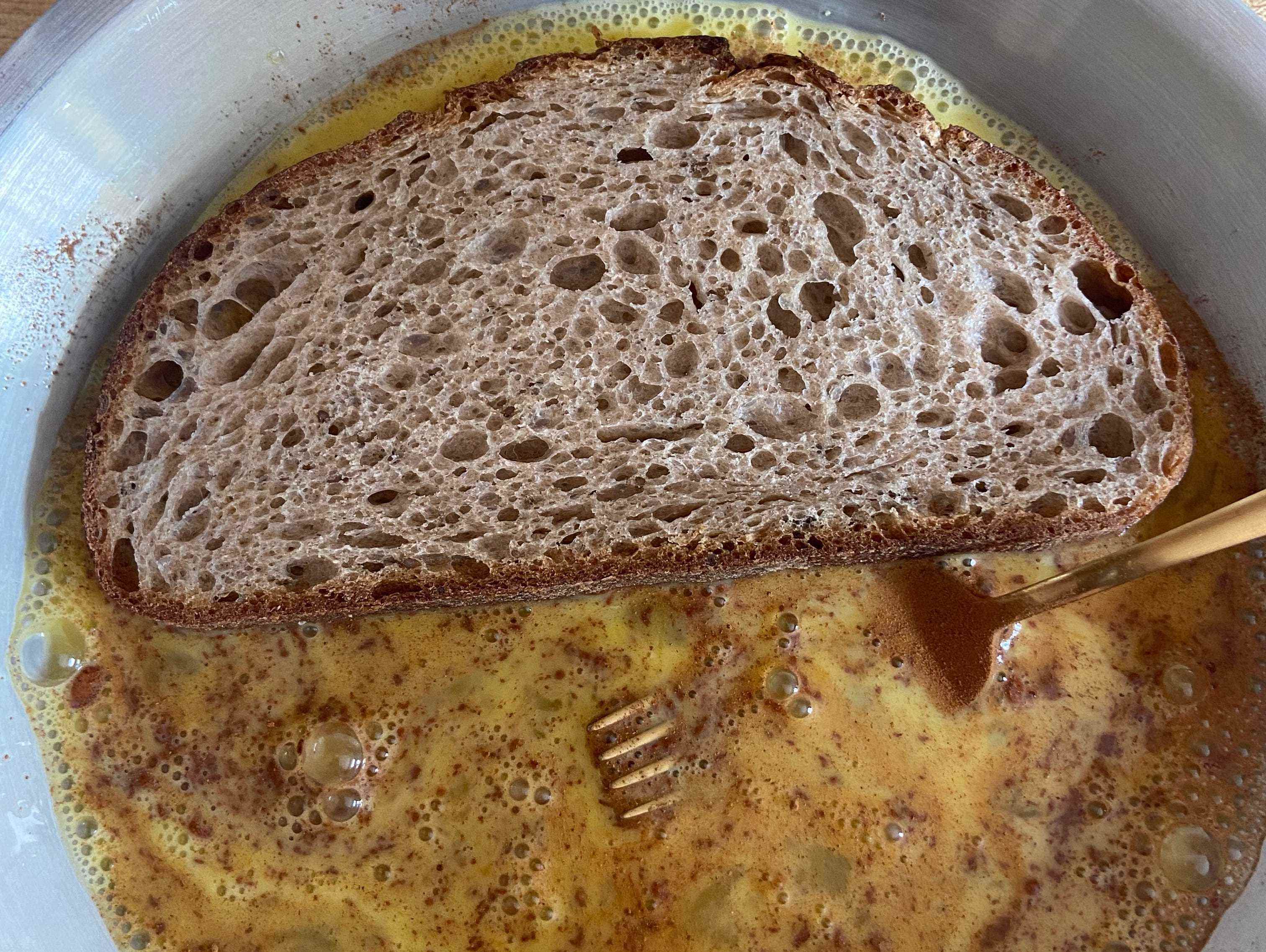 Brot, das in einer Eimischung für French Toast eingeweicht wird