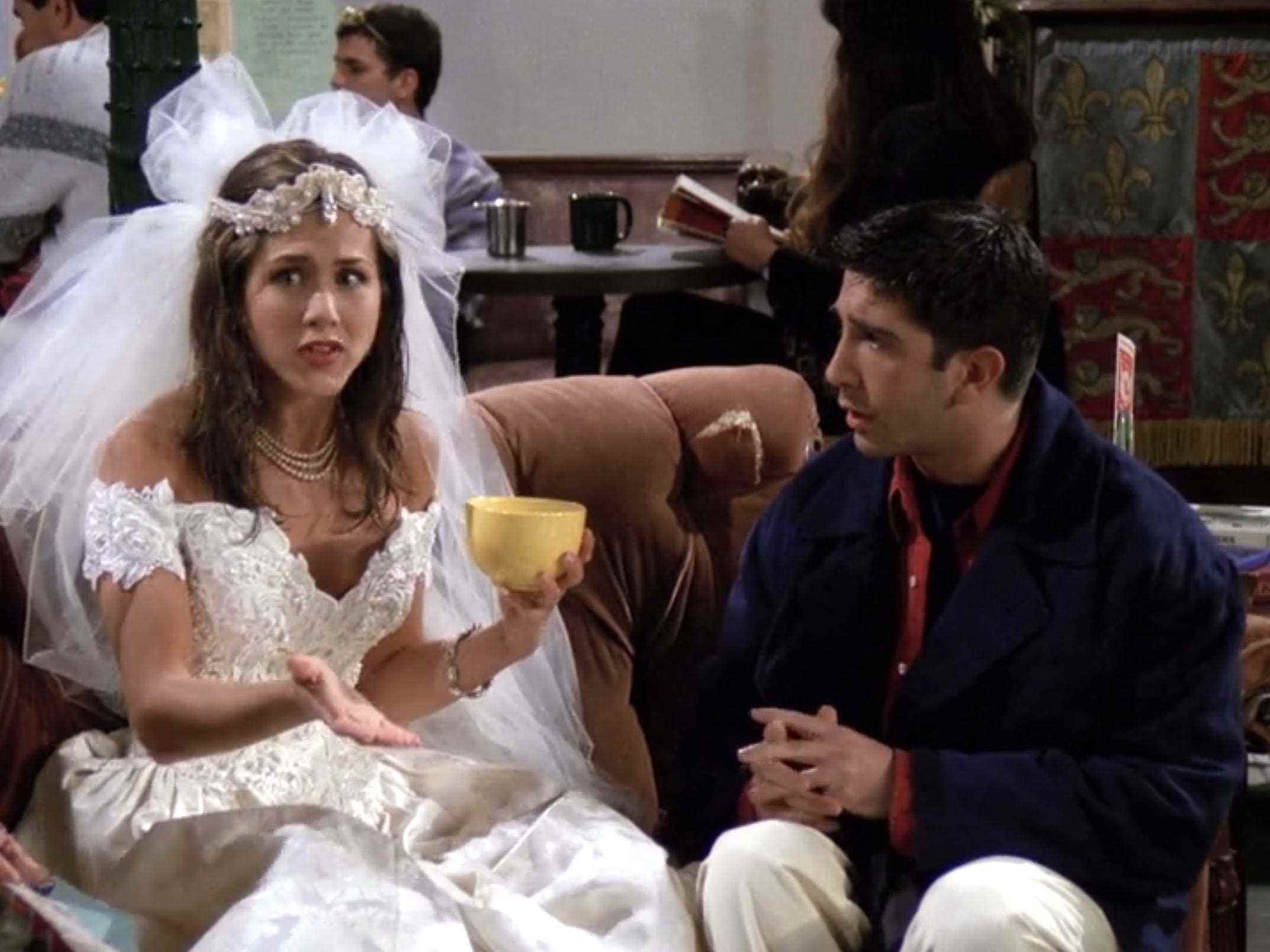 Jennifer Aniston und David Schwimmer sitzen bei der Serienpremiere von „Friends“ auf einer Couch.