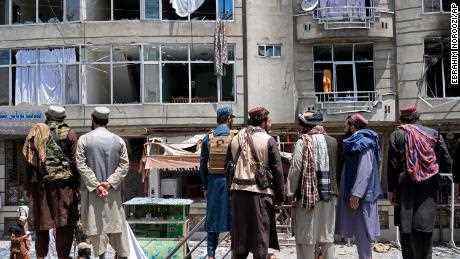 Taliban-Kämpfer versammeln sich am Samstag am Ort einer Explosion vor einem Sikh-Tempel in Kabul. 