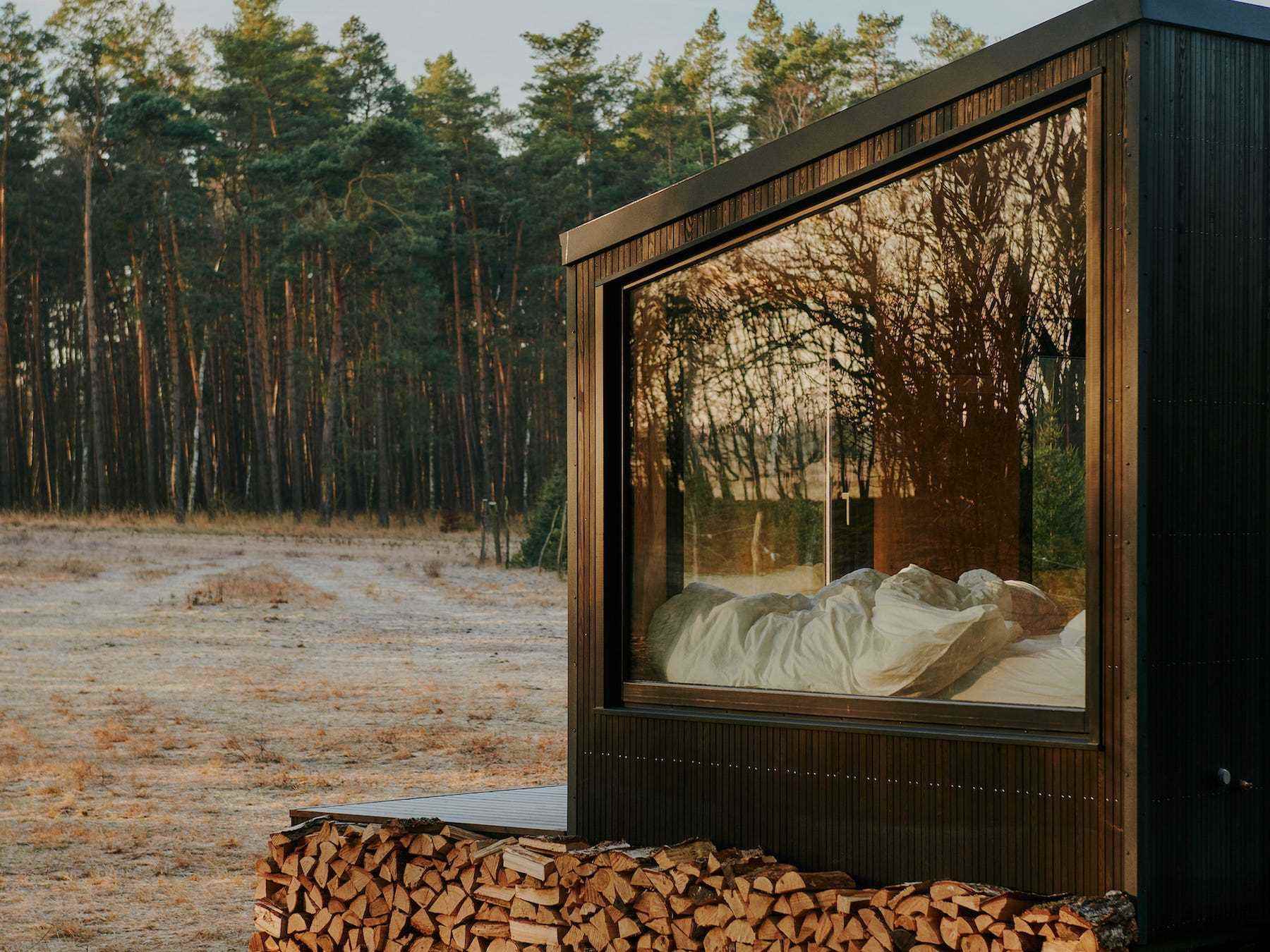 Eine Nahaufnahme einer Raus-Hütte in der Natur, umgeben von Bäumen und offenen Feldern.