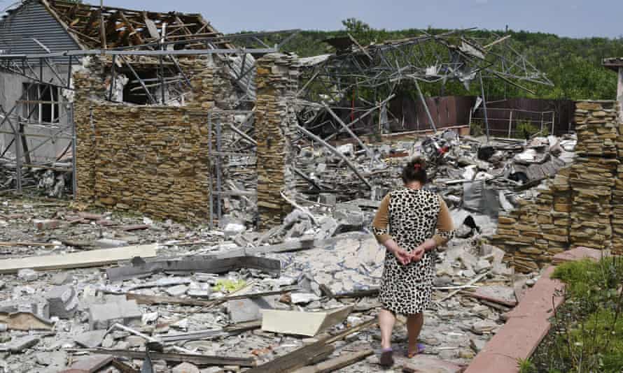 Eine ältere Frau geht neben einem Gebäude in Slowjansk, Ukraine, das durch einen nächtlichen Raketenangriff beschädigt wurde.