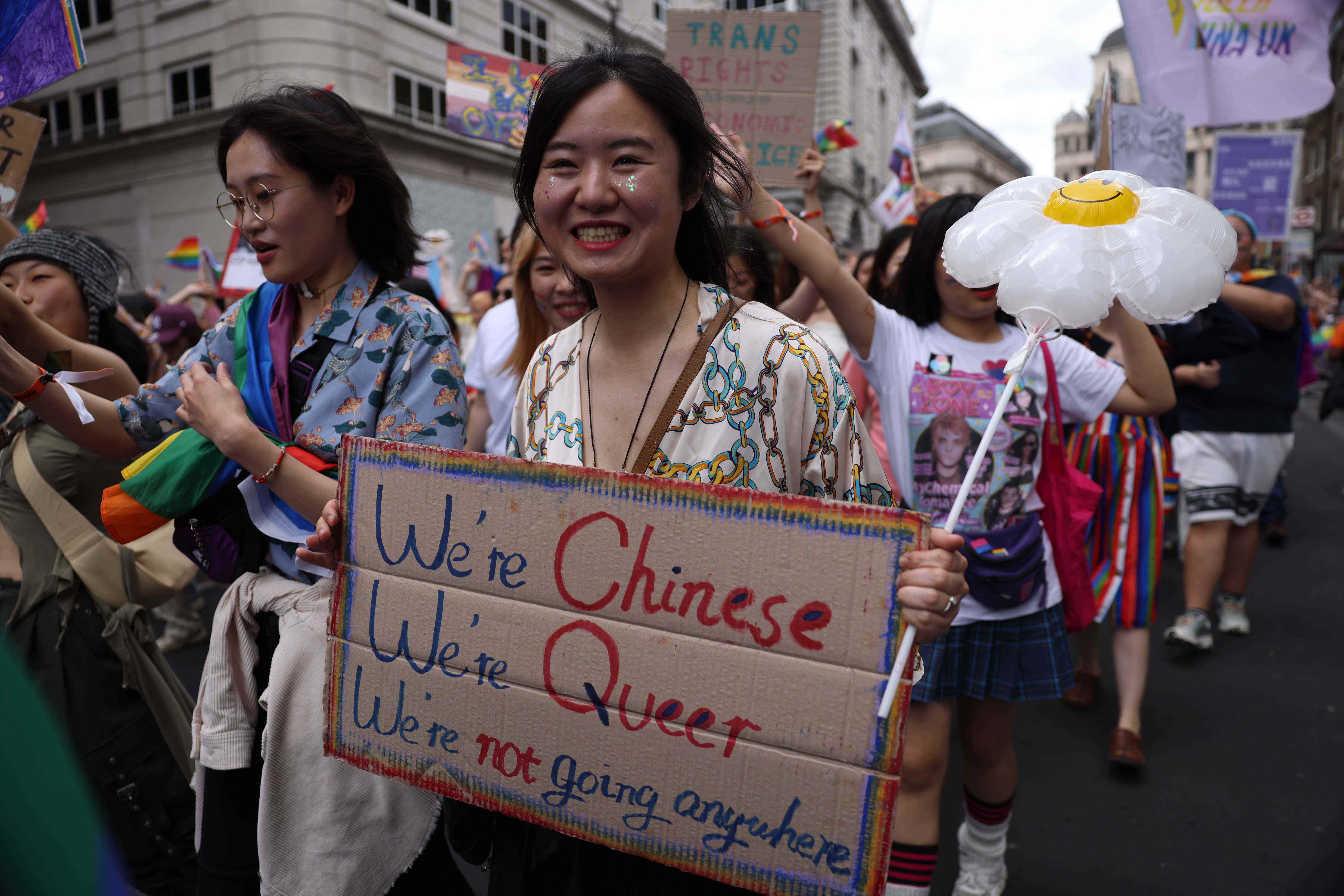 Frauen marschieren mit Schildern während der Parade 2022 Pride in London.