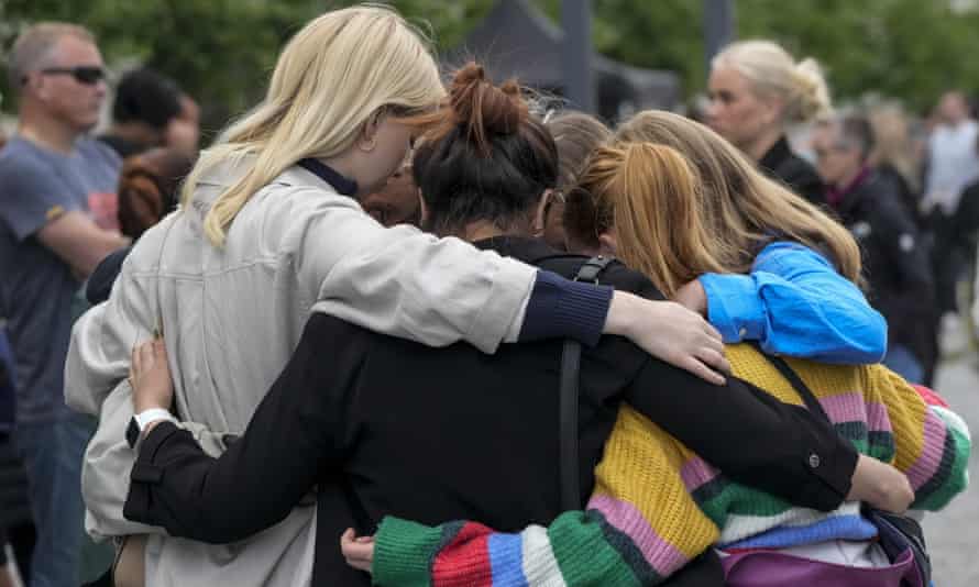 Menschen trösten sich gegenseitig bei einer Gedenkfeier für die Opfer einer Massenerschießung in Kopenhagen.