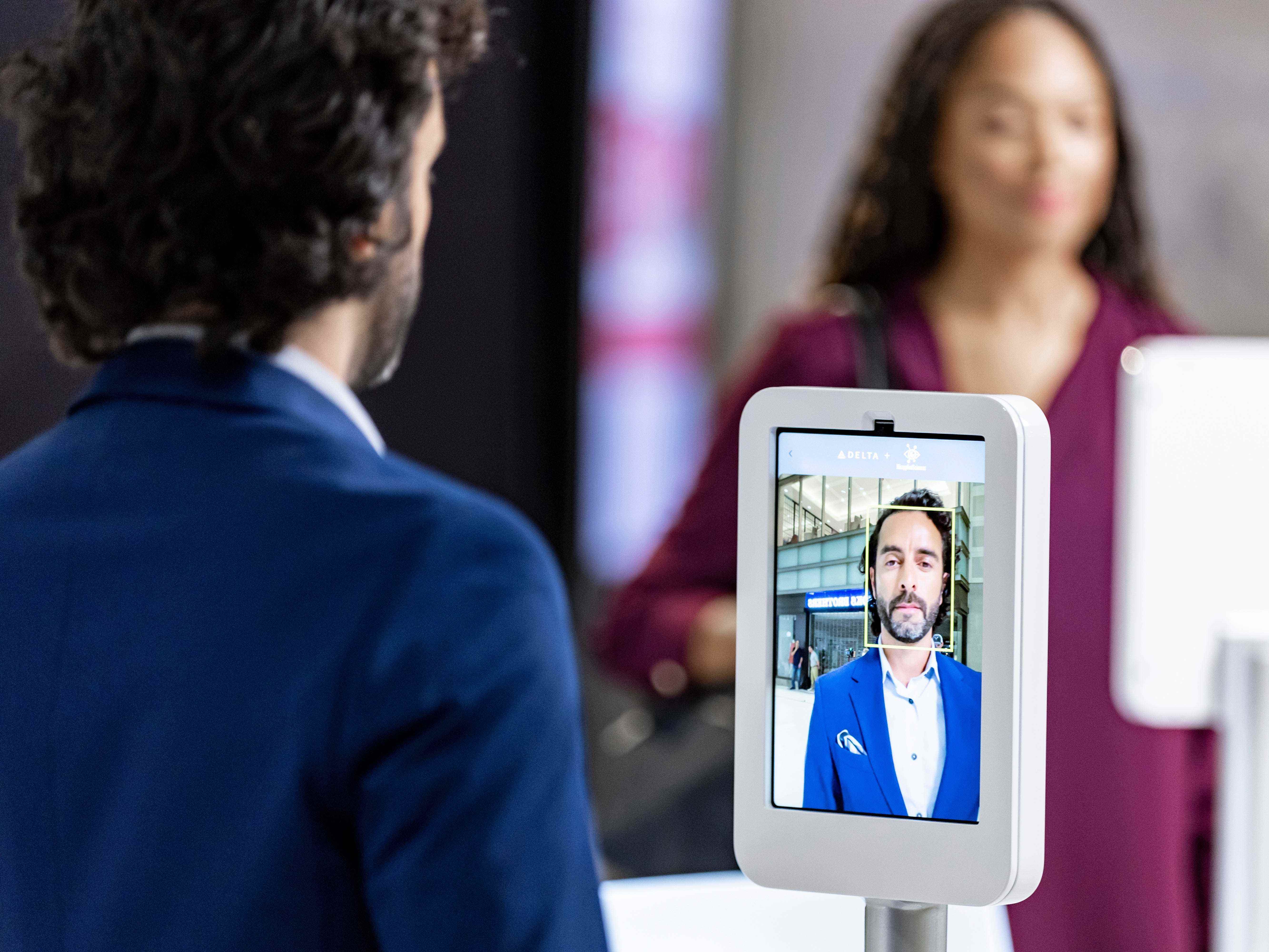 Ein Mann verwendet eine Gesichtserkennungstechnologie, um sich für die Verwendung des Parallel Reality-Bildschirms zu registrieren.