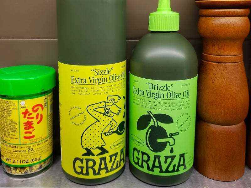 Zwei Flaschen Graza-Olivenöl neben anderen Gewürzen.