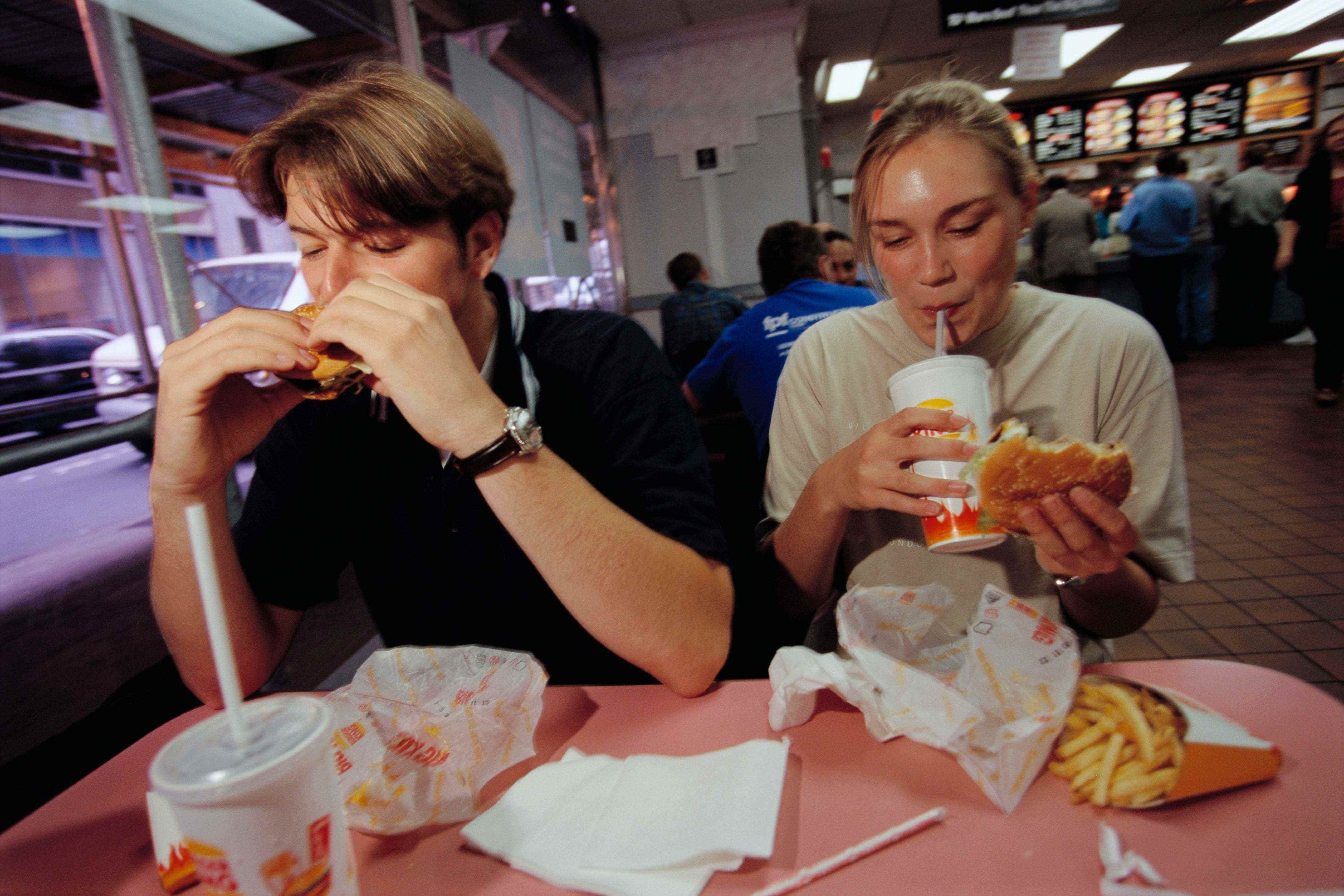 Zwei Kunden beim Essen und Trinken in einem Burger King-Restaurant am 10. September 1997