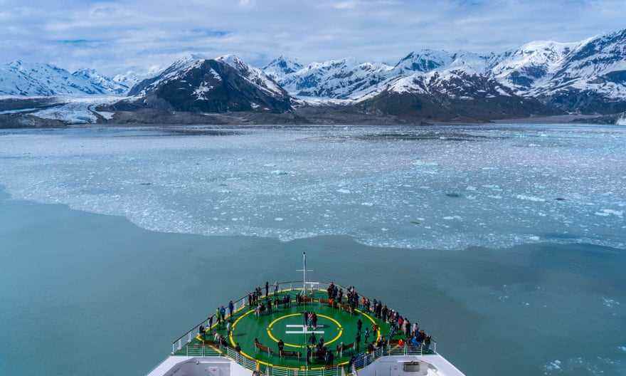 Kreuzfahrtschiff, das in Richtung eines Gletschers segelt, mit Passstand auf dem Hubschrauberlandeplatz des Schiffs, mit Blick auf einen riesigen Eisberg.