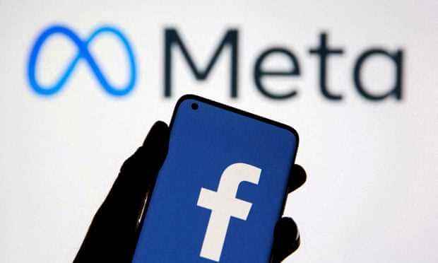 ein smartphone mit dem facebook-logo wird gegen eine anzeige des meta-logos auf weißem hintergrund gehalten