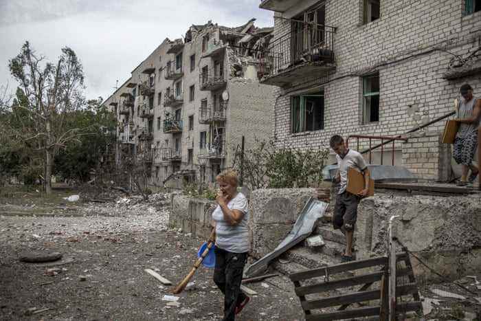 Anwohner sammeln ihre Habseligkeiten aus ihren Häusern, die durch Beschuss eines Wohngebäudes in der ukrainischen Region Donezk beschädigt wurden.