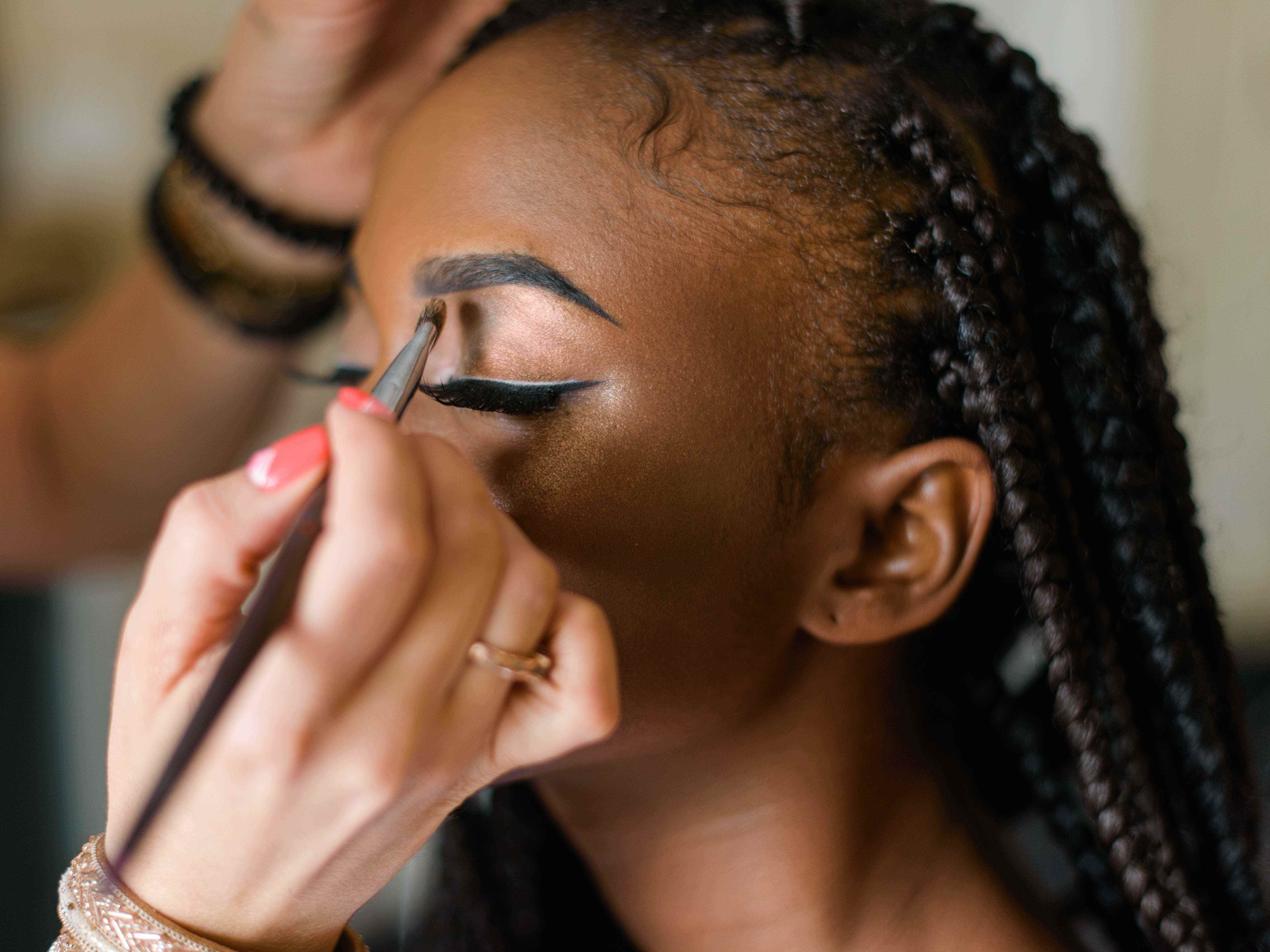 Make-up-Künstler kreieren einen Look mit kräftigen Brauen für einen Kunden