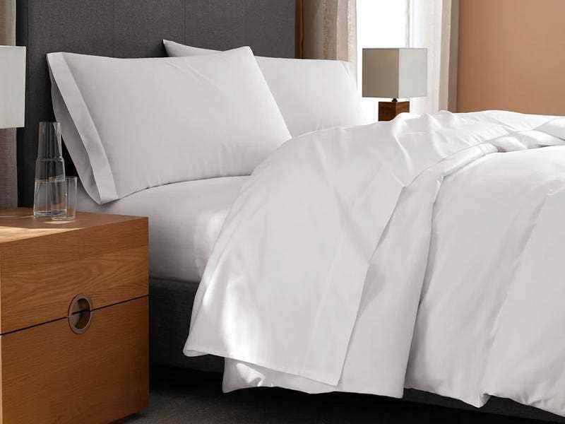 Seitenansicht des vollständig gemachten weißen Bettes in Laken von h by frette.