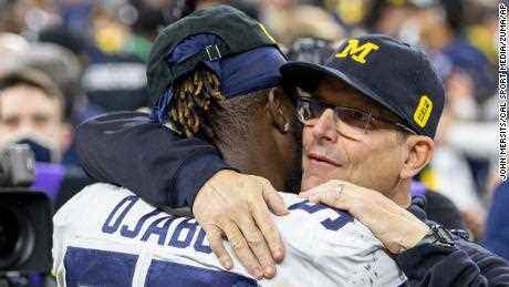 Ojabo und Michigan-Cheftrainer Jim Harbaugh umarmen sich nach einem Spiel gegen die Iowa Hawkeyes.