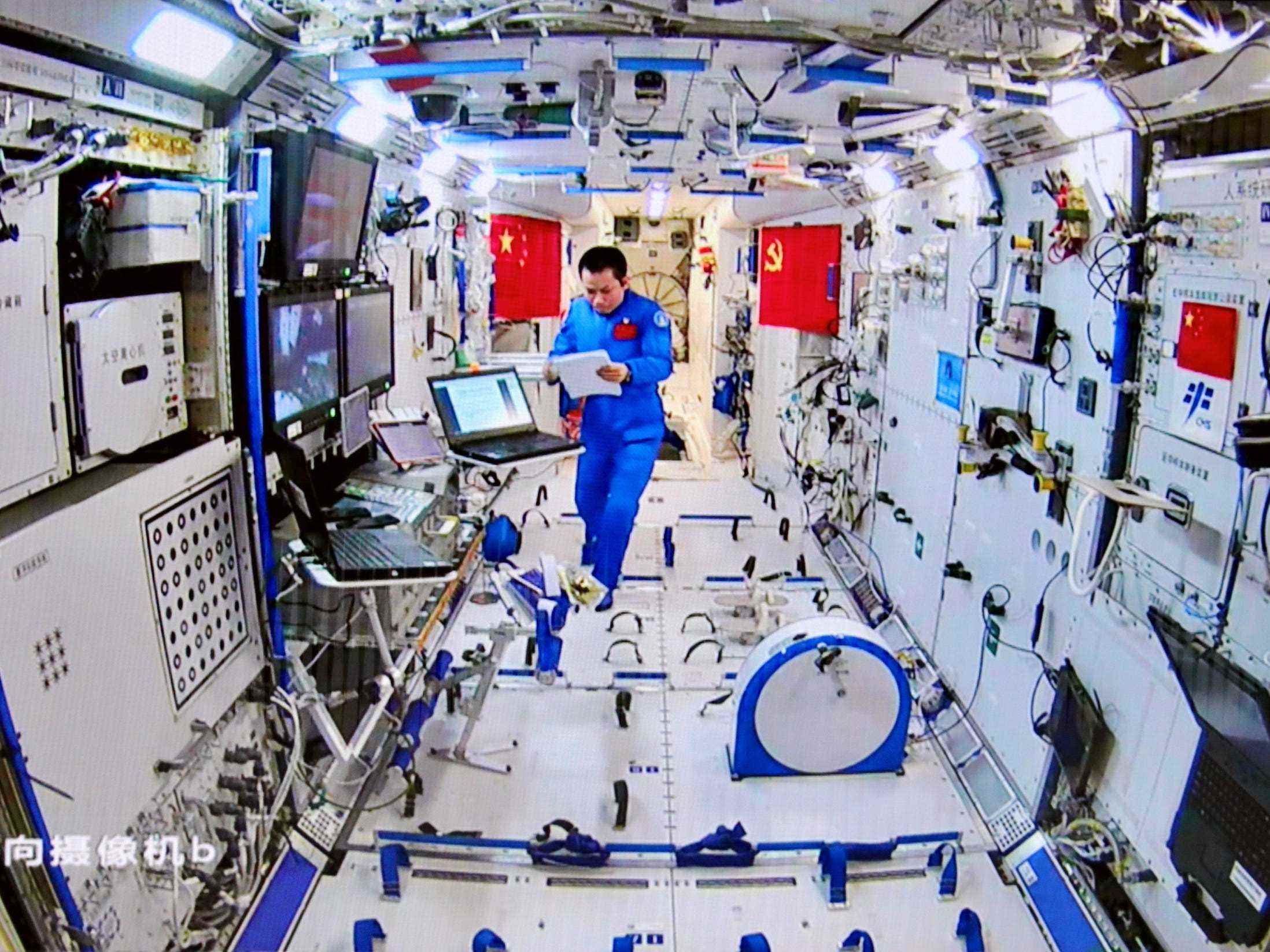 astronaut taikonaut in der chinesischen raumstation, der papiere im blauen overall betrachtet