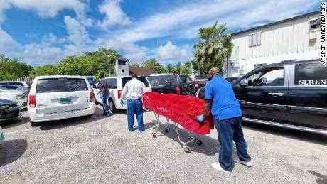 Die Leiche eines der Toten wird von Leichenbestattern in Nassau weggebracht. 