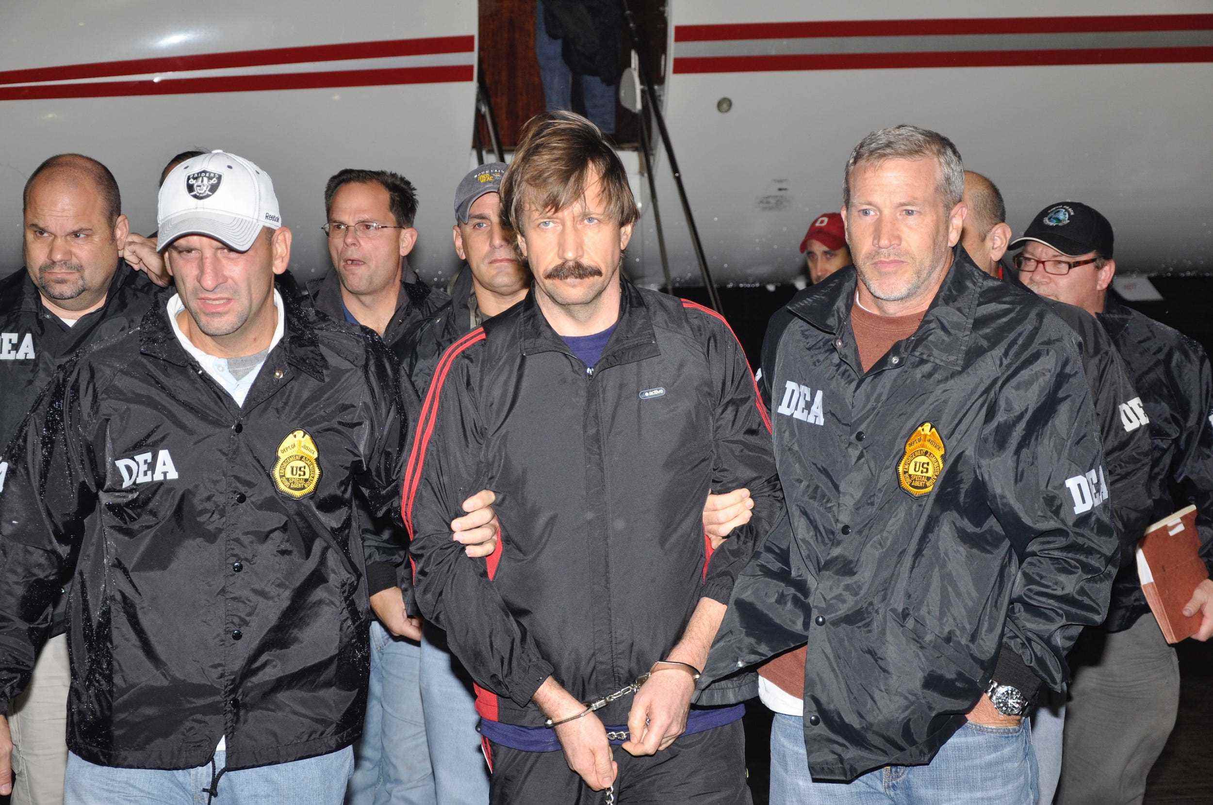 DEA-Agenten eskortieren Viktor Bout (Mitte) aus dem Flugzeug, nachdem er an die Vereinigten Staaten ausgeliefert wurde.