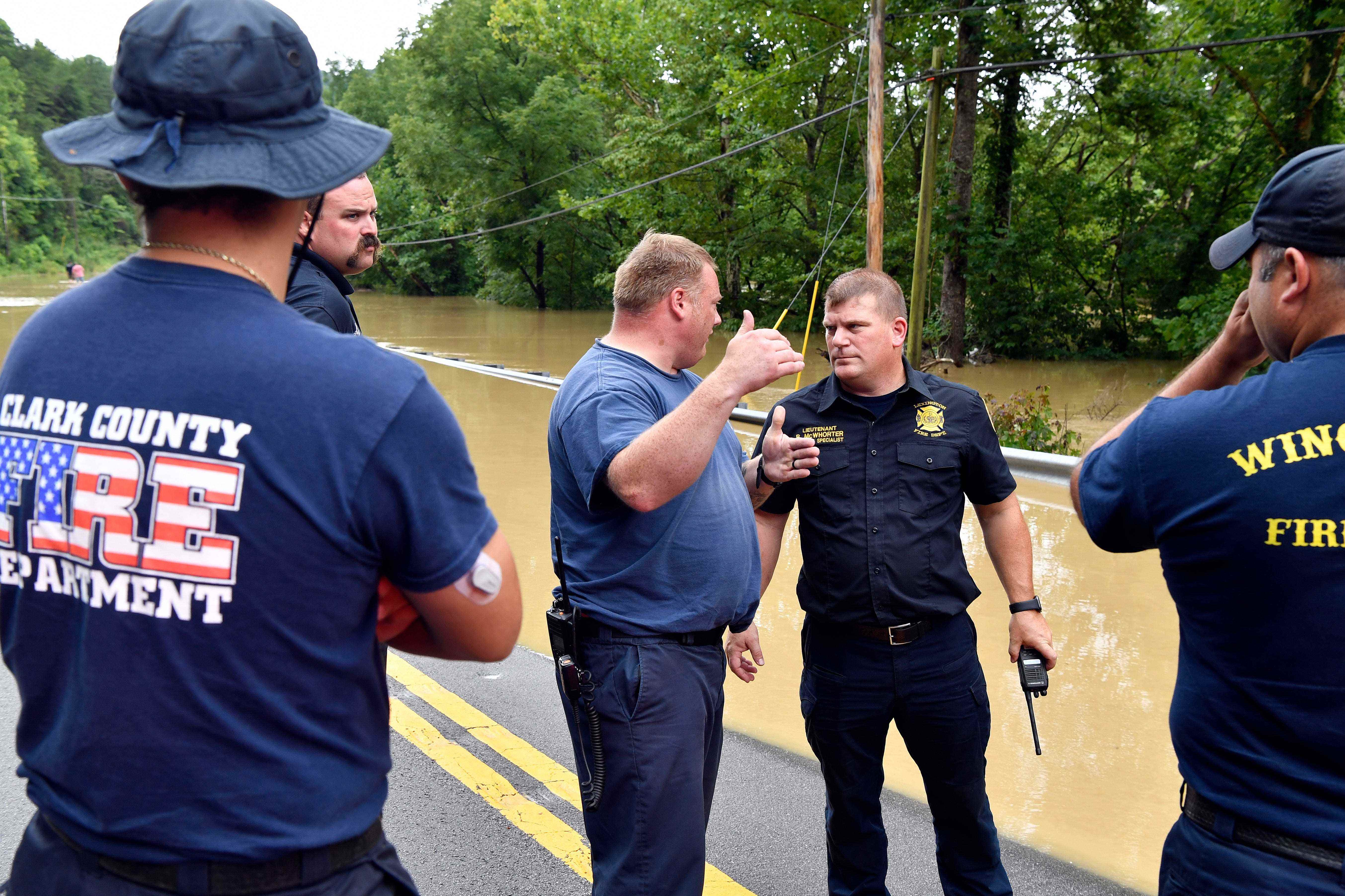 Rettungskräfte sprechen in der Nähe von trüben Fluten in Kentucky miteinander.