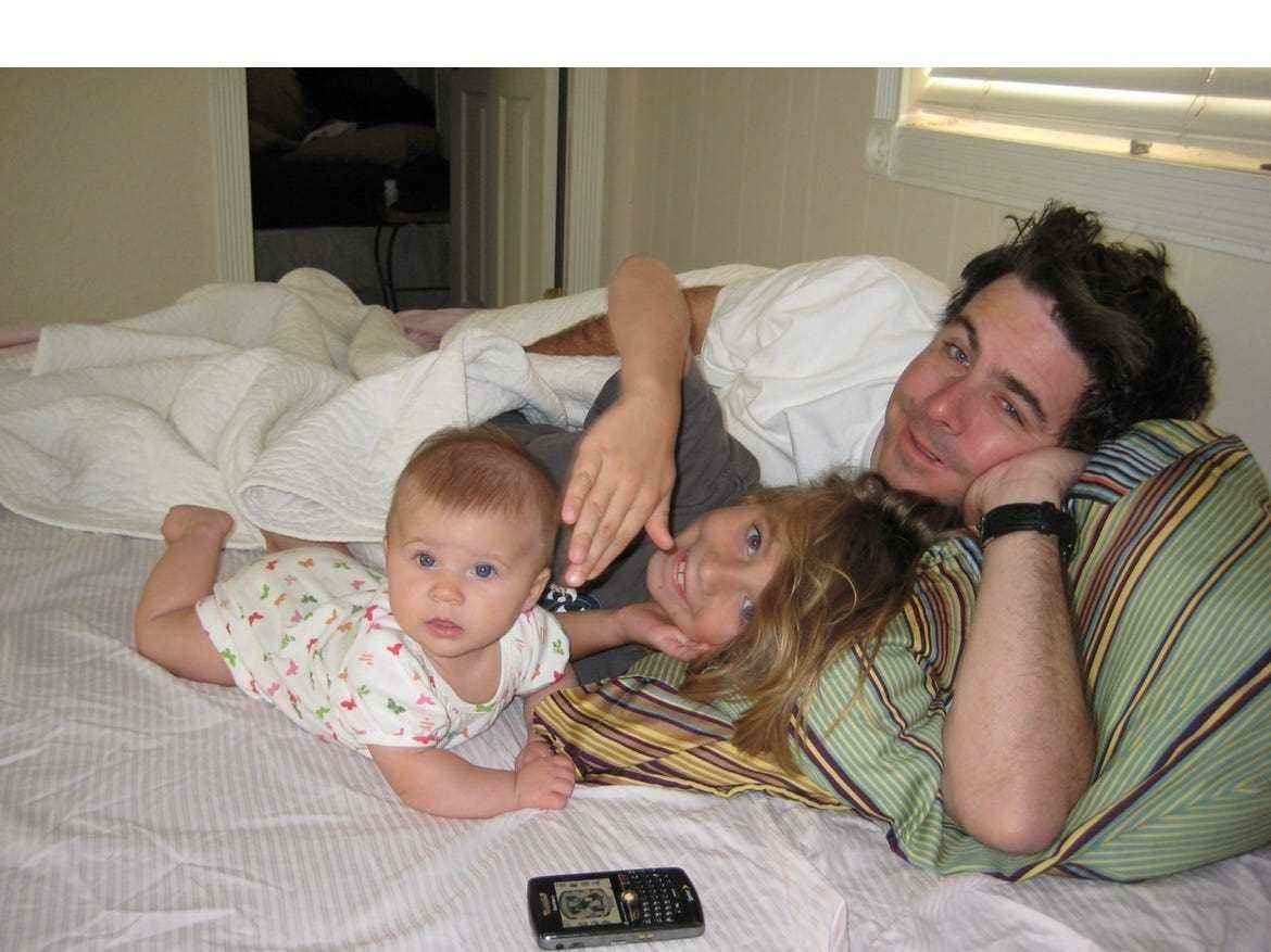 Gavin Alsop liegt 2009 mit seinem Sohn Gavin und seinem zweiten Kind Piper im Bett, den Kopf auf ein Kissen gestützt.