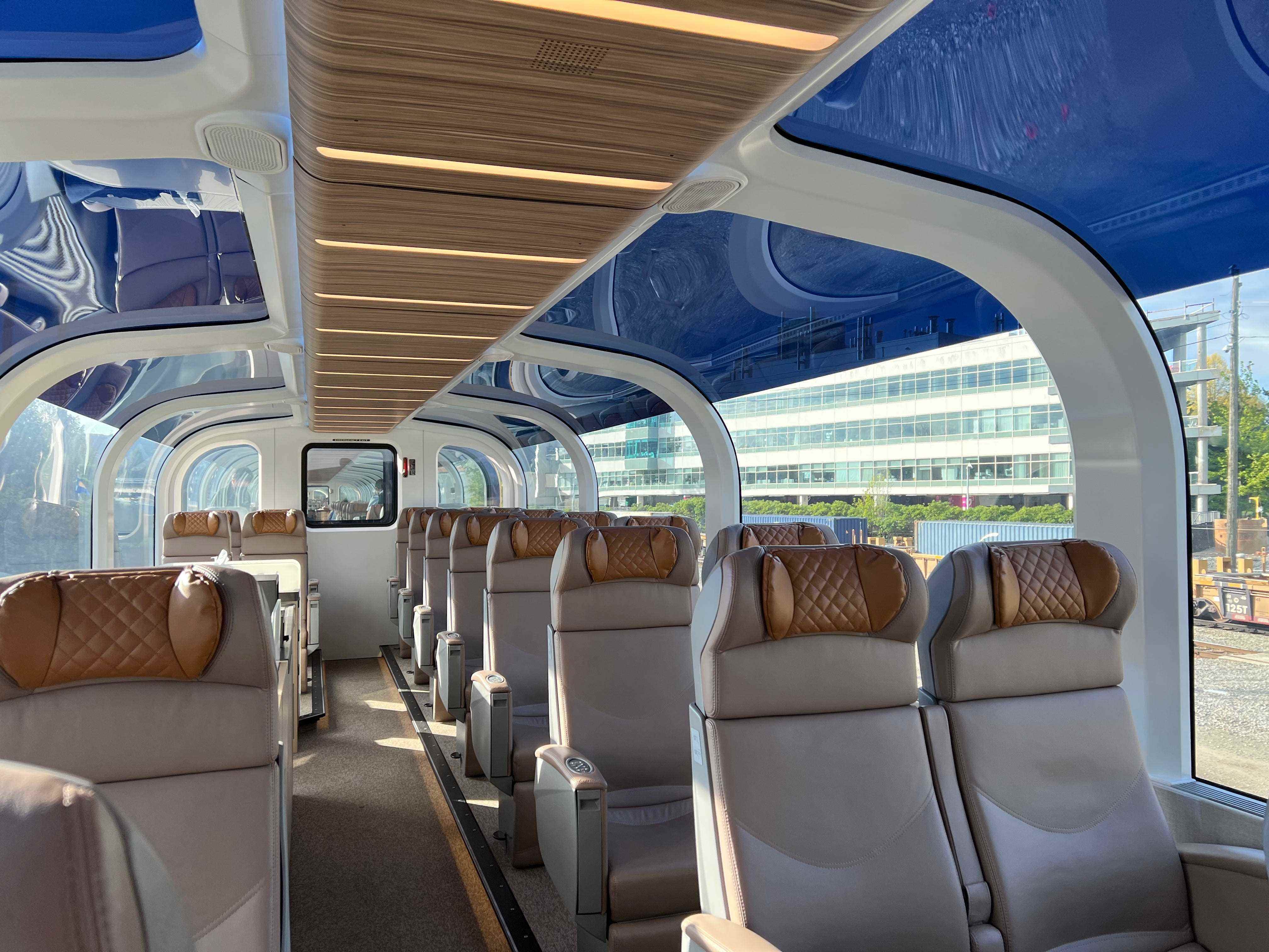 Hellbraune Sitze und blaue Decke mit einem Glasdachbereich in einem Zug