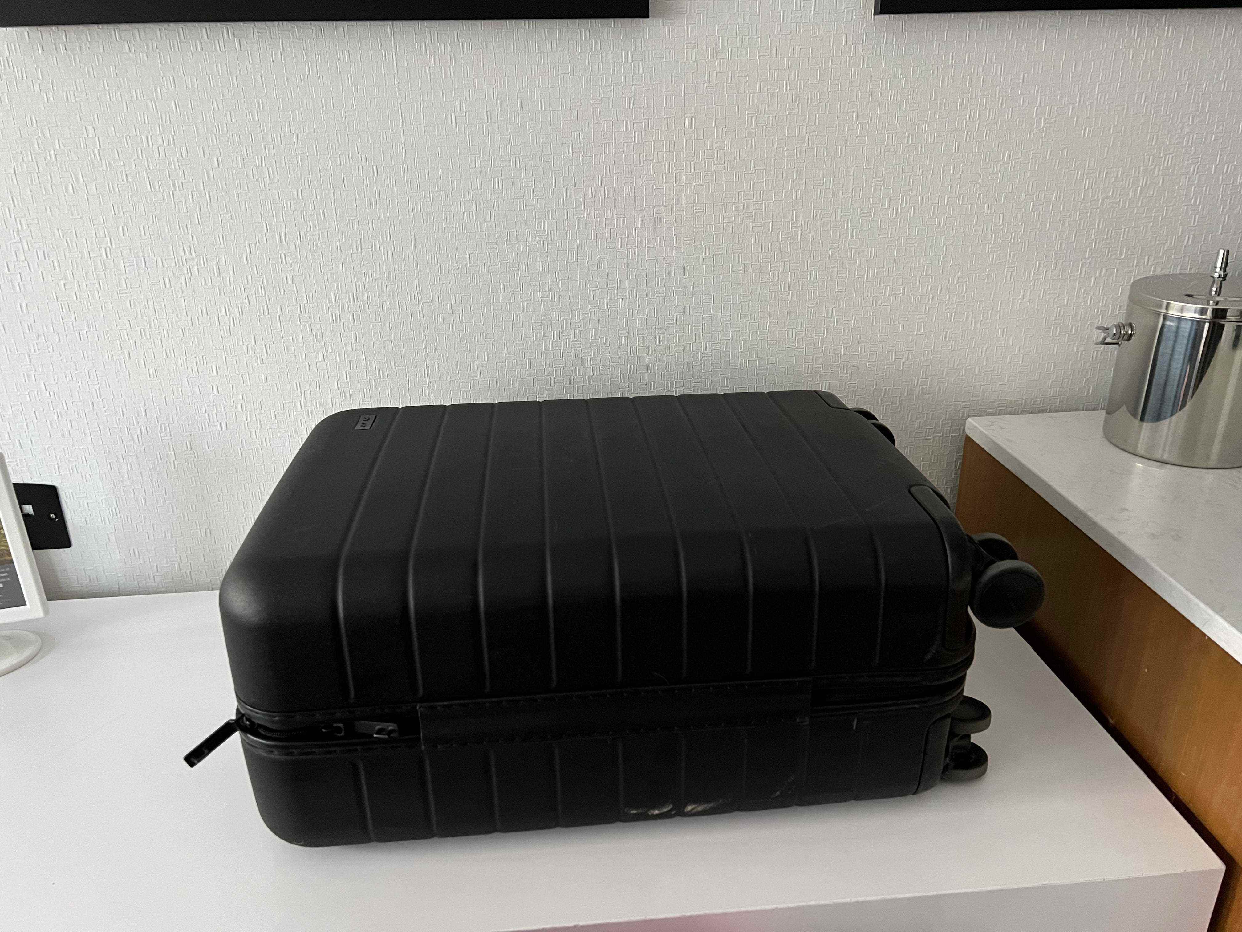 Schwarzer Koffer auf weißer Theke im Hotelzimmer