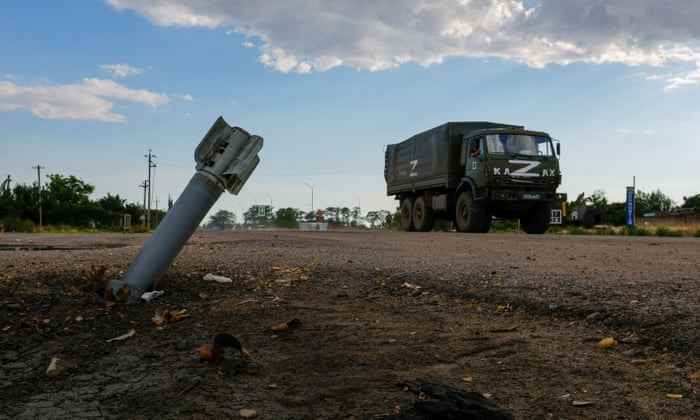 Ein russischer Militärlastwagen fährt an einem Blindgänger im Dorf Chornobaivka in der Region Cherson in der Ukraine vorbei.