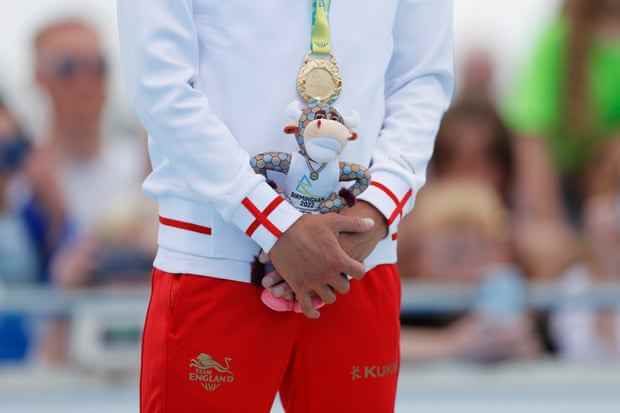 Alex Yee vom Team England steht mit seiner Medaille und seinem Maskottchen auf dem Podium, nachdem er im Einzel-Sprint-Triathlon-Finale der Männer Gold gewonnen hat.