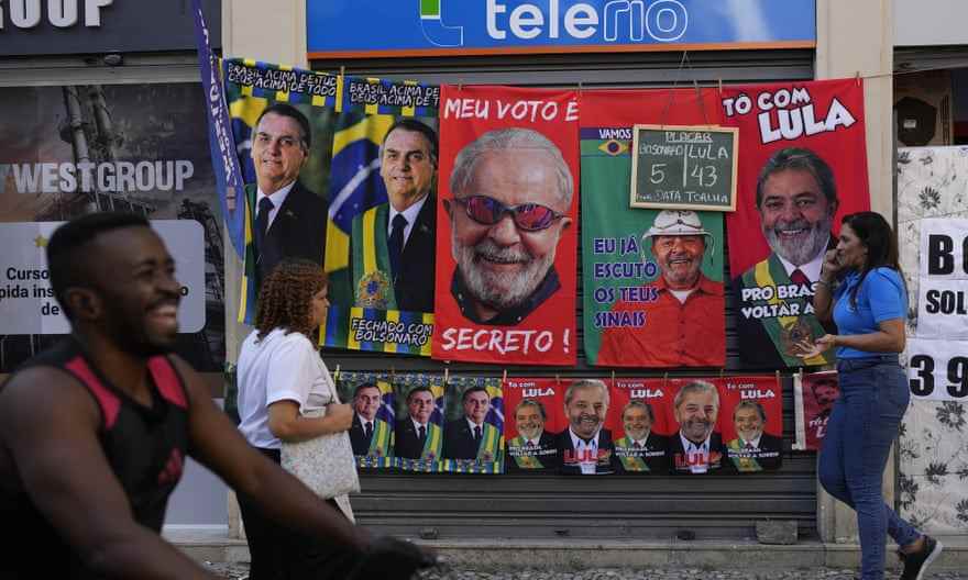 Handtücher mit Präsident Jair Bolsonaro (links) und dem ehemaligen Präsidenten Luiz Inacio da Silva oder Lula hängen zum Verkauf neben einer Tafel, auf der die täglichen Verkaufszahlen des Verkäufers für jedes Handtuch für den Präsidentschaftskandidaten im letzten Monat in Rio de Janeiro zu sehen sind