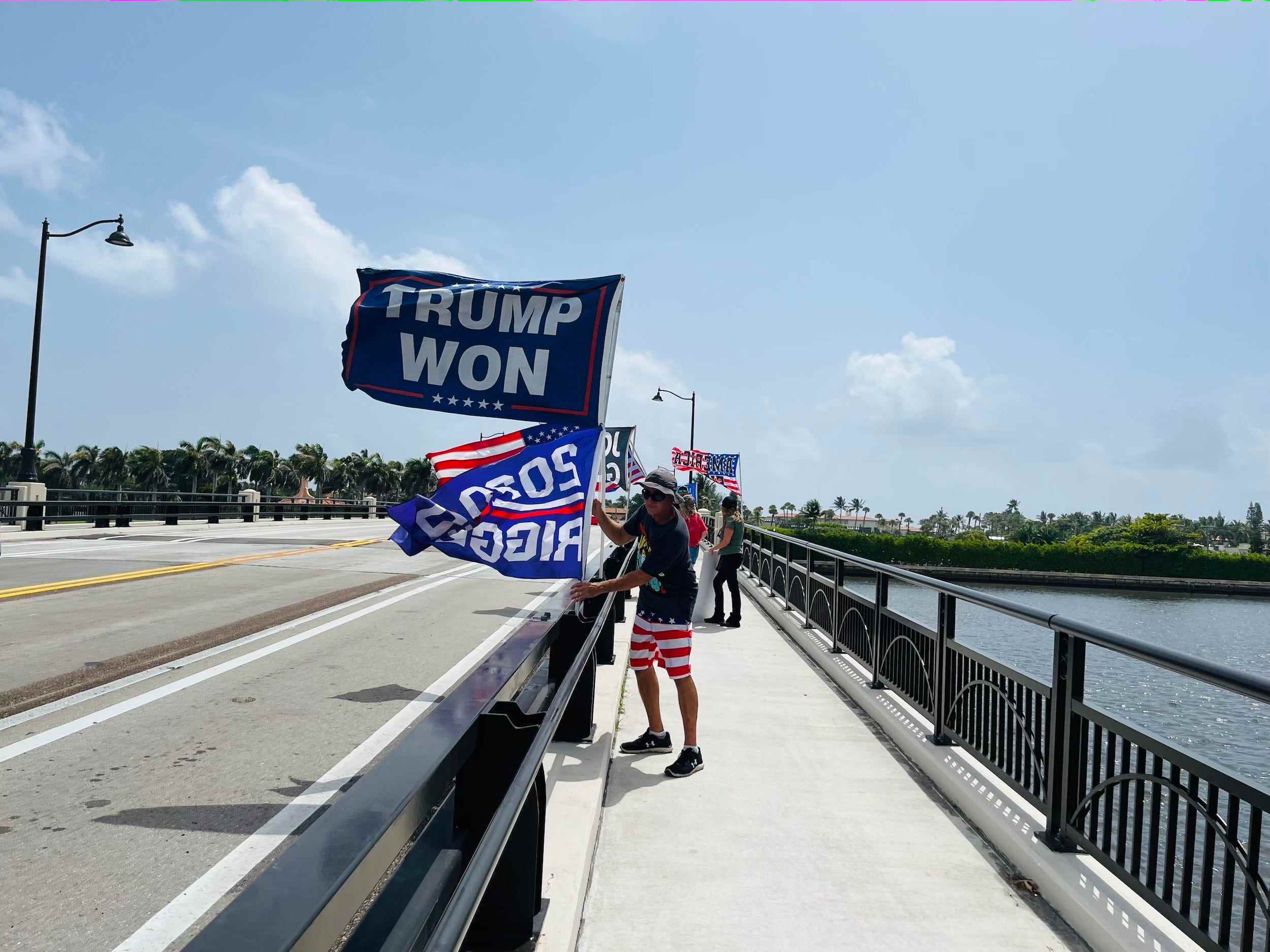 Ein Trump-Anhänger hält außerhalb von Mar-a-Lago eine „Trump hat gewonnen“-Flagge hoch.