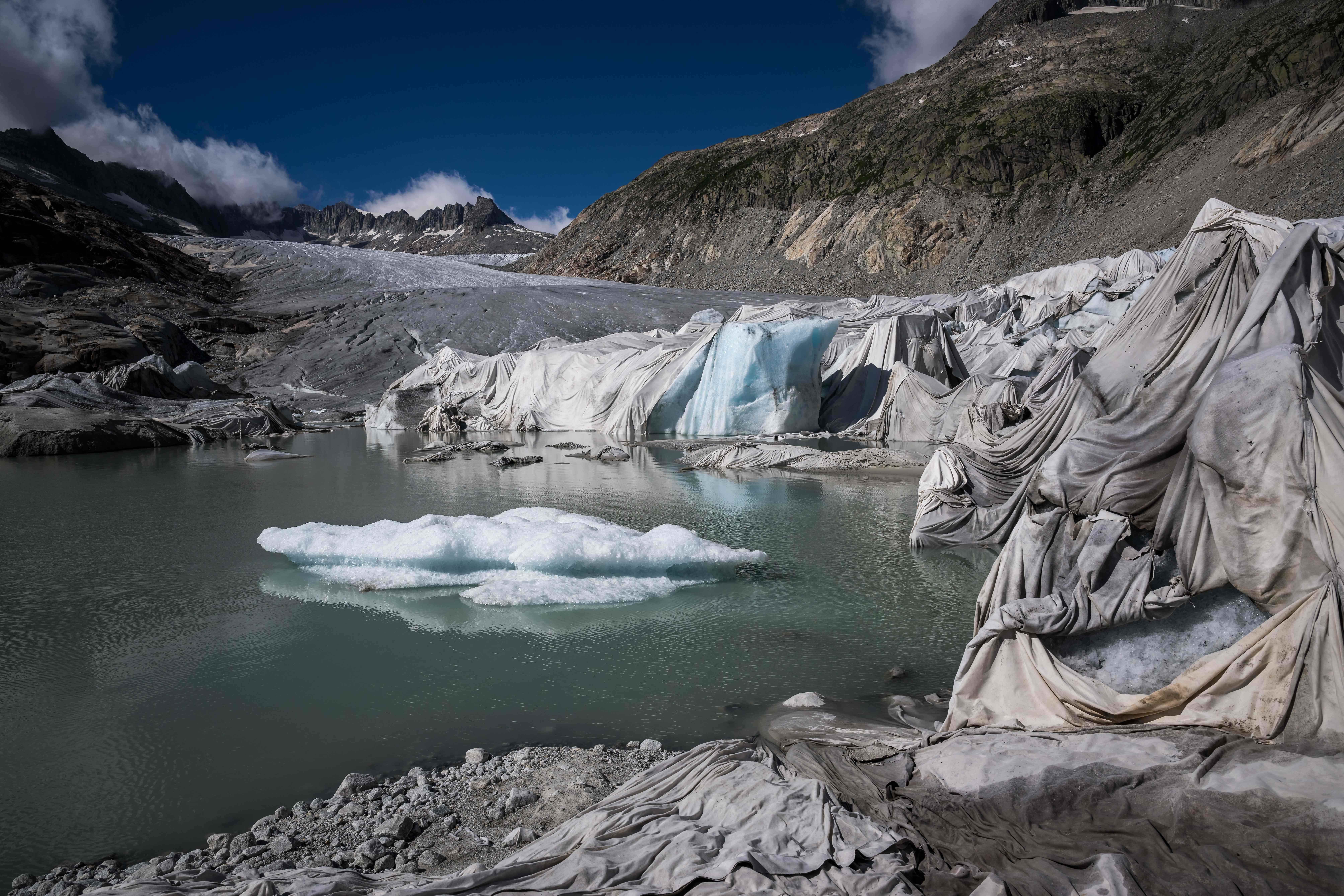 Dieses Foto, das am 8. Juli 2022 in der Nähe von Gletsch in den Schweizer Alpen aufgenommen wurde, zeigt Isolierschaum, der einen Teil des Rhonegletschers bedeckt, um zu verhindern, dass er neben seinem Gletschersee schmilzt.