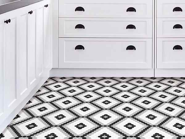 Ein Küchenboden mit Bodenbelag aus weißen und grauen Vinylfliesen mit Rautenmuster.