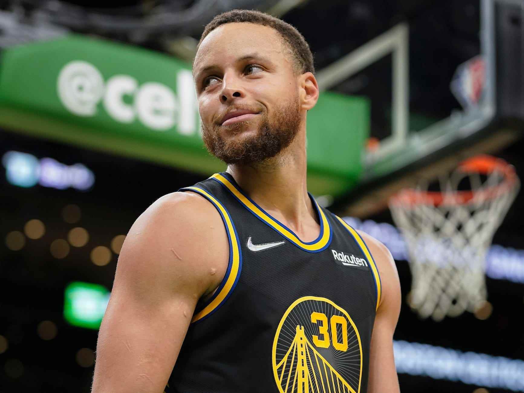 Stephen Curry sieht weg und lächelt während eines NBA-Finalspiels.