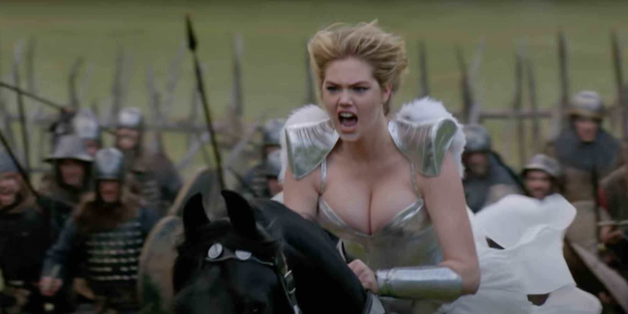 Ein Screenshot aus einer Werbung für Game of War aus dem Jahr 2014, der eine schreiende Kate Upton zu Pferd mit Soldaten hinter sich zeigt.