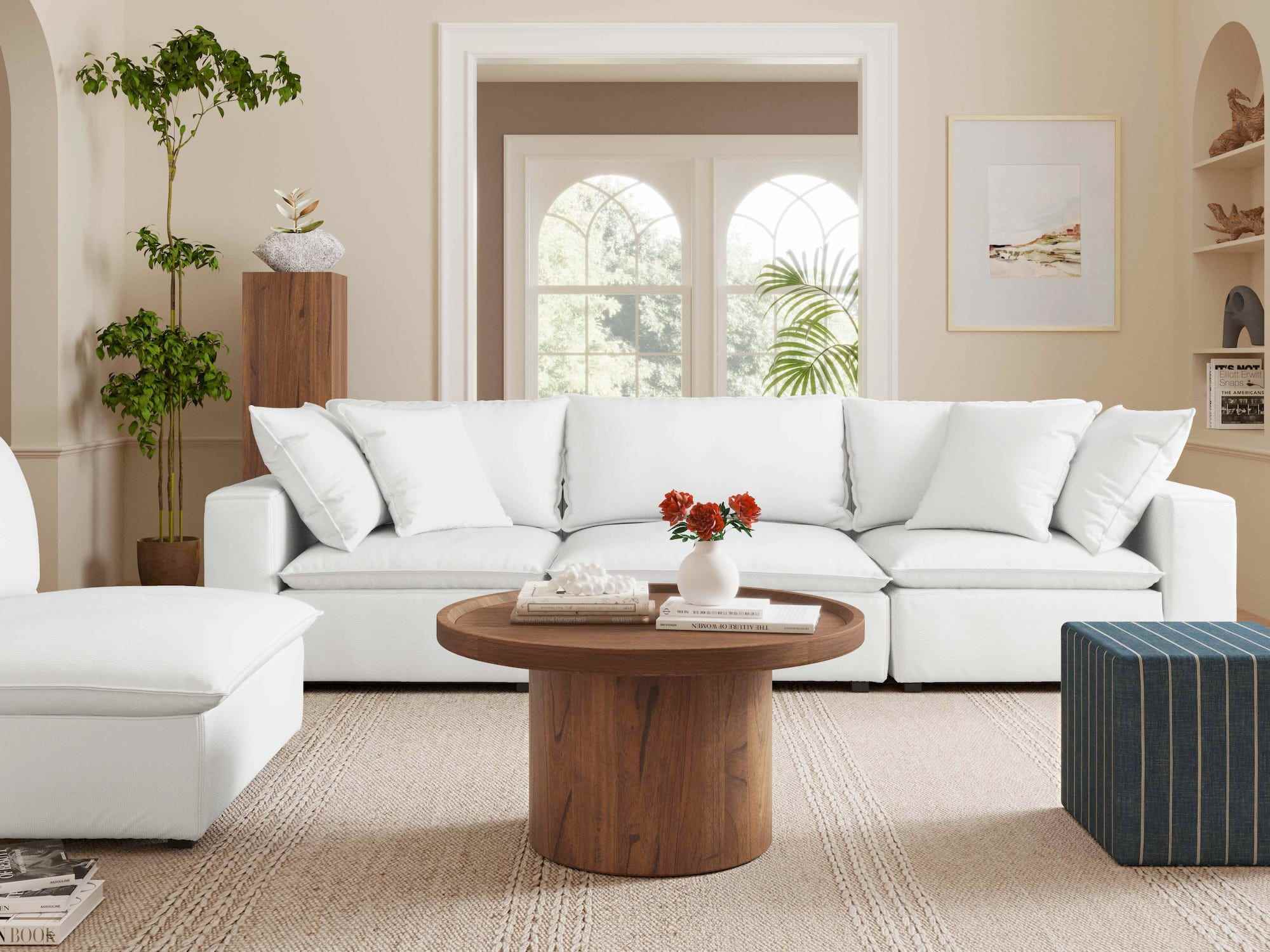 Ein weißes TOV Furniture Cali Peal Tweed Modular Sofa steht in einem Wohnzimmer neben einem weißen Stuhl und einem hölzernen Couchtisch.