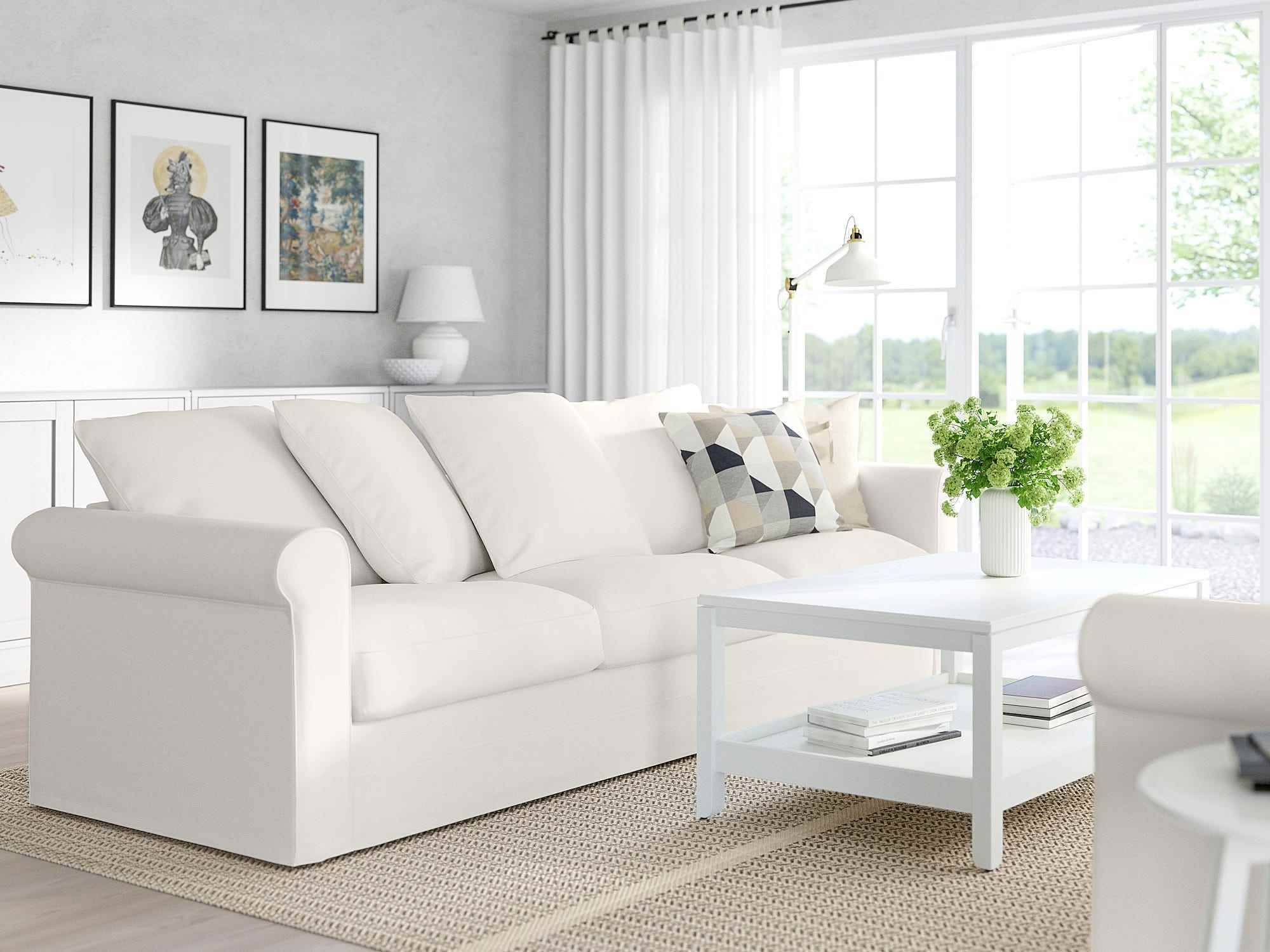 Ein weißes Ikea-Harlanda-Sofa steht in einem Wohnzimmer gegenüber einer anderen Couch mit einem Tisch dazwischen.