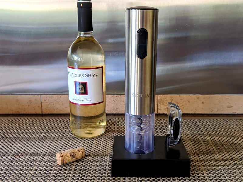 Ein elektrischer Weinöffner steht neben einer Flasche Weißwein von Charles Shaw, um zu demonstrieren, wie man eine Weinflasche mit einem elektrischen Korkenzieher 2022 öffnet.