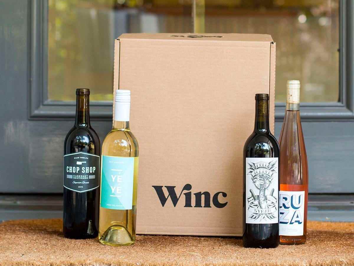 Vier Flaschen Wein mit einer braunen Weinkiste in der Mitte als Geschenke für Schwiegereltern im Jahr 2022.