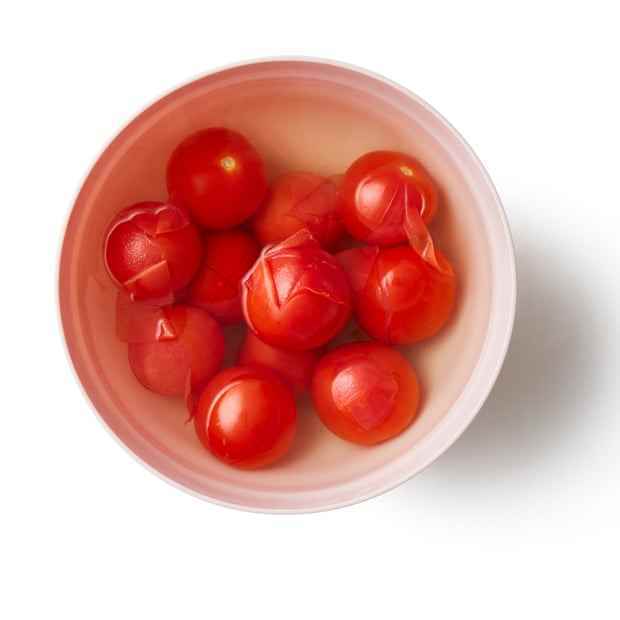 Die Tomaten in eine hitzebeständige Schüssel geben, mit kochendem Wasser bedecken und eine Minute ruhen lassen, bis sich die Haut auflöst.  Die Schalen abtropfen lassen, schälen und wegwerfen