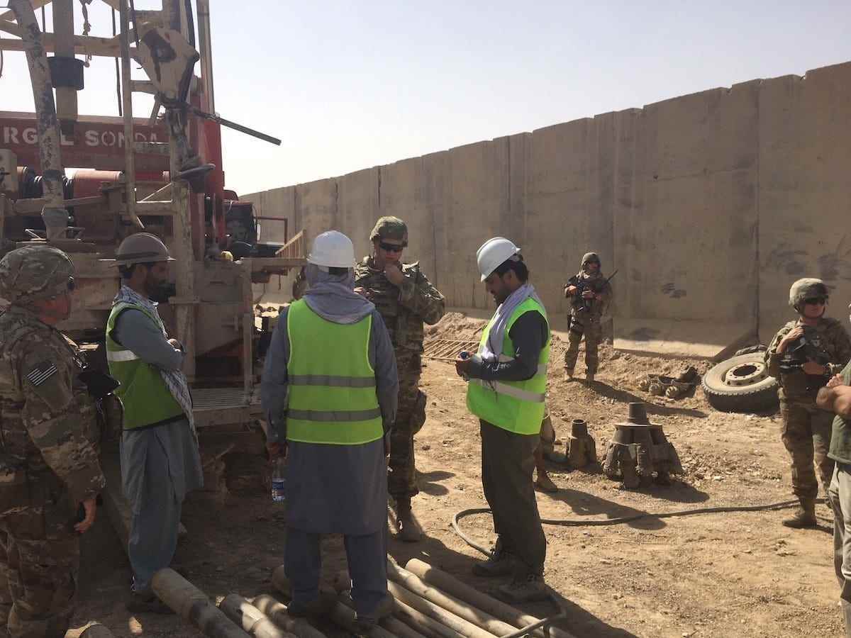 Der Vertreter der Baukontrolle, James Fielden, der lokale Vertreter der nationalen Qualitätssicherung, und der Projektingenieur Brian Cagle des USACE-Distrikts Afghanistan besprechen mit den Auftragnehmern des Abfall- und Wasserbehandlungsprojekts Kandahar Air Wing die Bohrarbeiten für einen neuen Wasserbrunnen