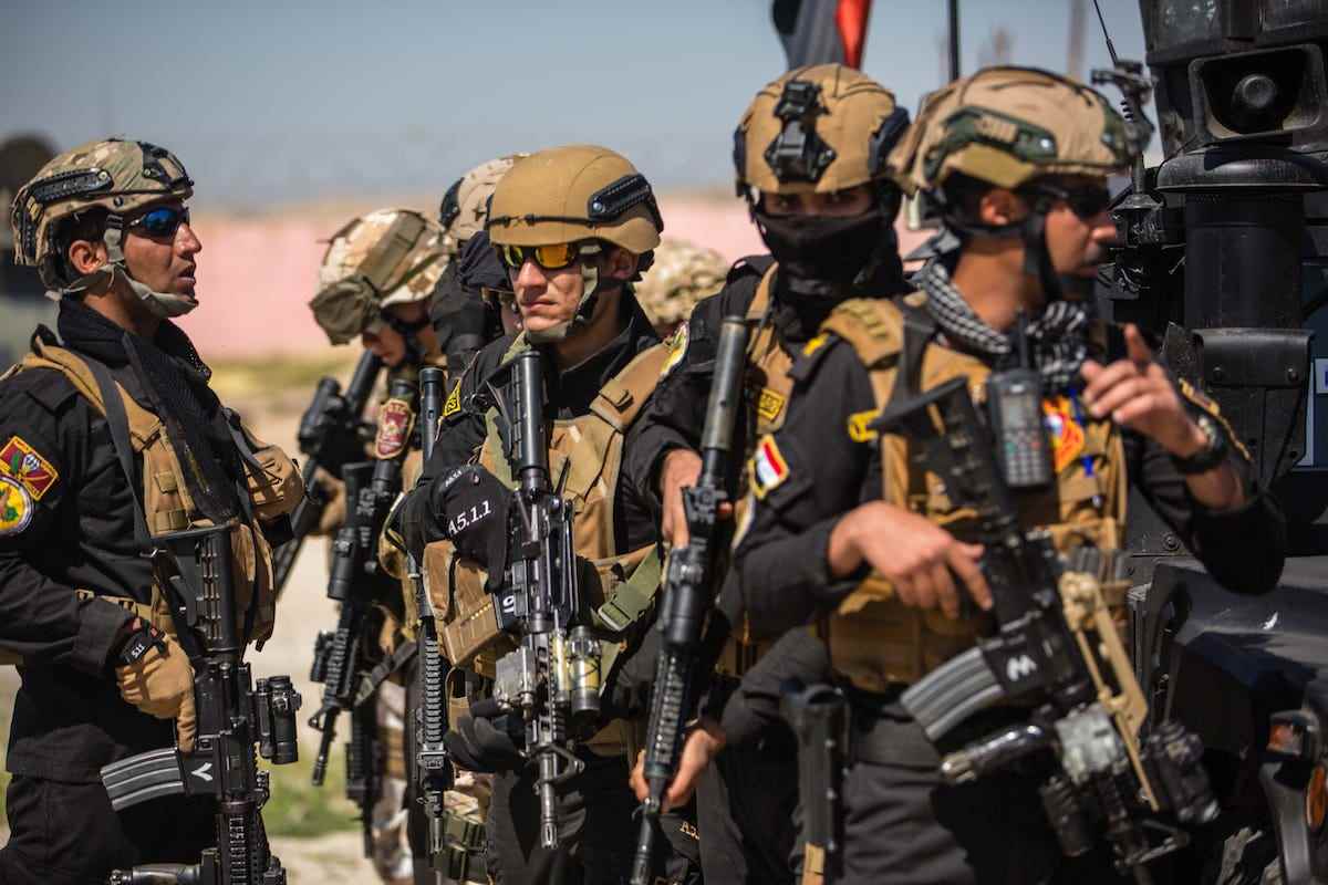 Italienische Soldaten, die zur Unterstützung der Operation Inherent Resolve eingesetzt werden, und Mitglieder der irakischen Anti-Terror-Truppe nutzen ein militärisches Kampffahrzeug als Deckung, bevor sie sich während der militärischen Ausbildung in Mossul, Irak, am 5. April 2018 auf ein Ziel zubewegen.