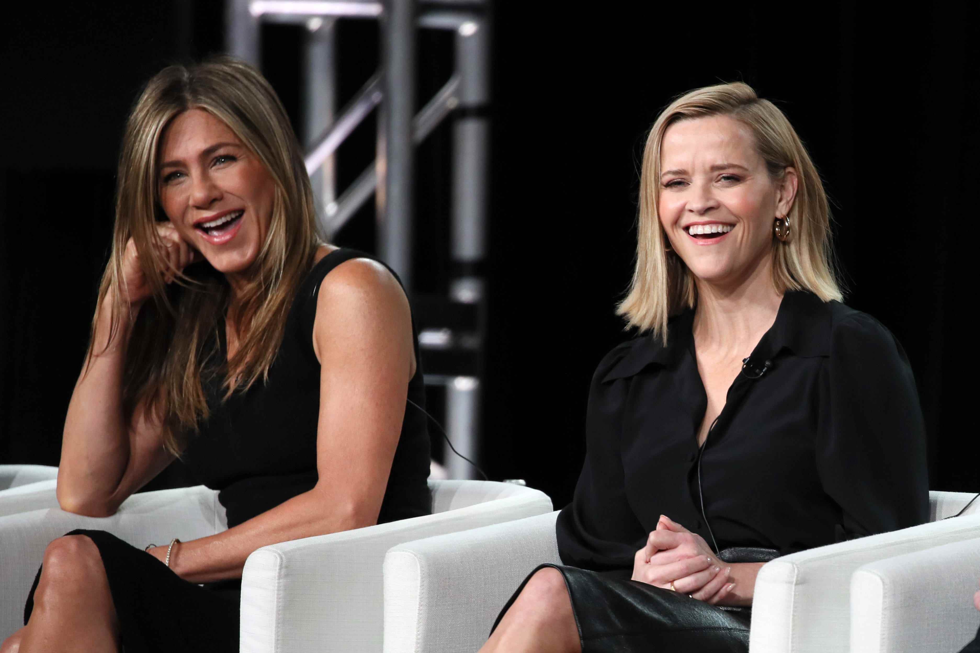Reese Witherspoon und Jennifer Aniston lachend auf der Bühne