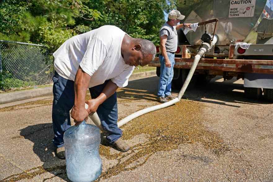 Menschen füllen am 31. August einen Fünf-Gallonen-Krug aus einem Wassertanker in Jackson.
