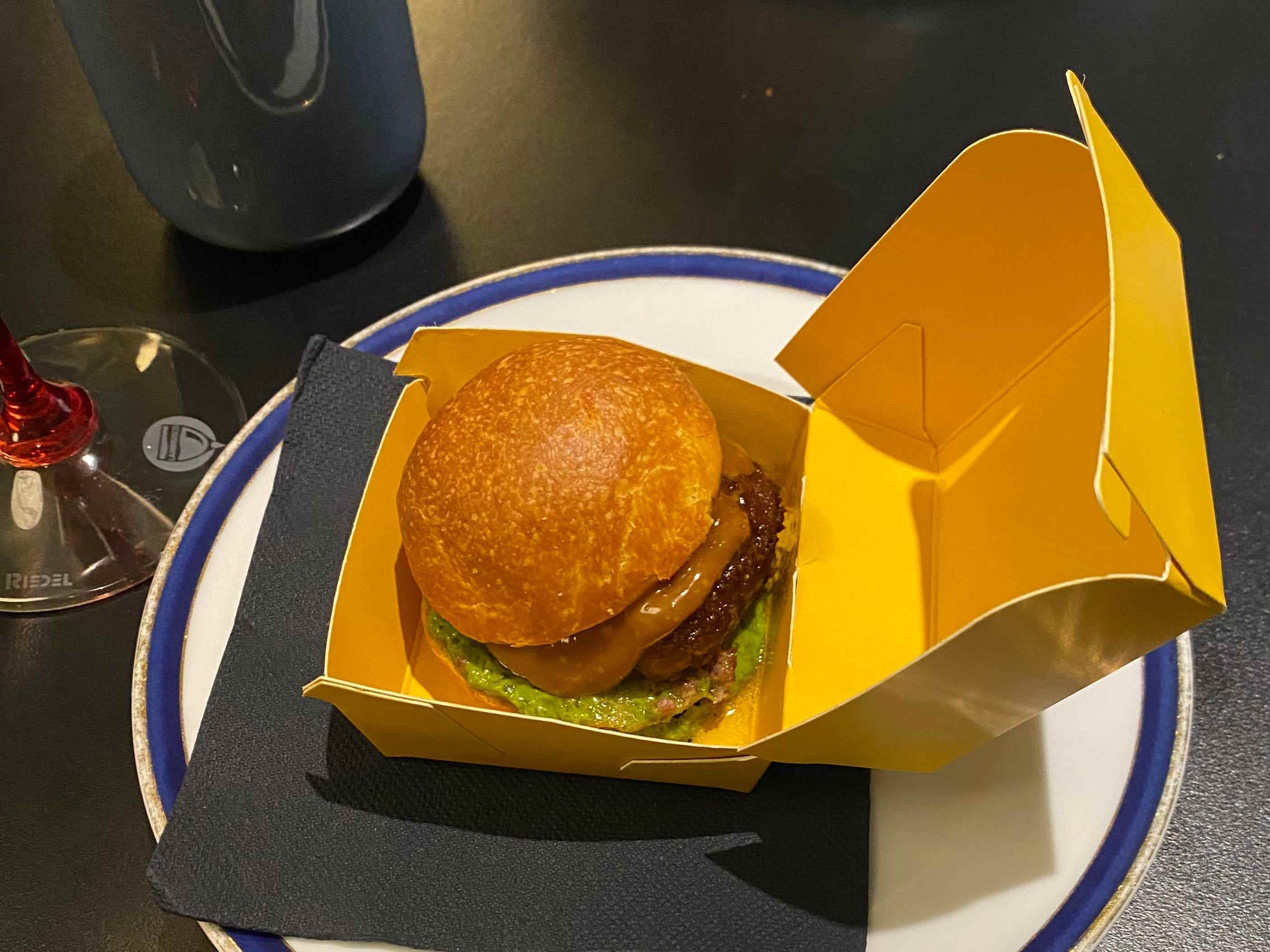 ein Burger in einem gelben Karton auf einem Teller bei Franceschetta58