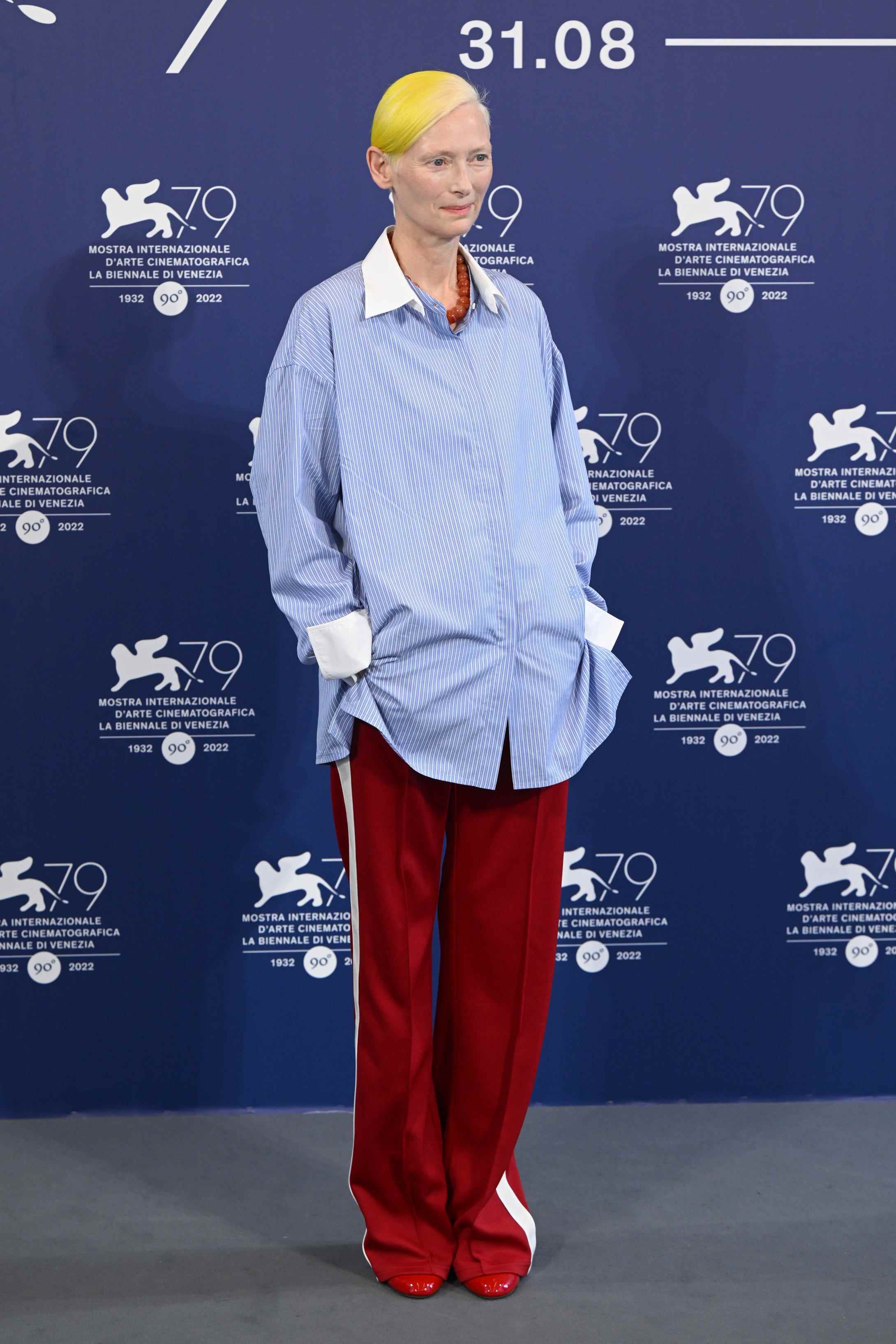 Tilda Swinton in einem blauen Hemd und einer roten Hose