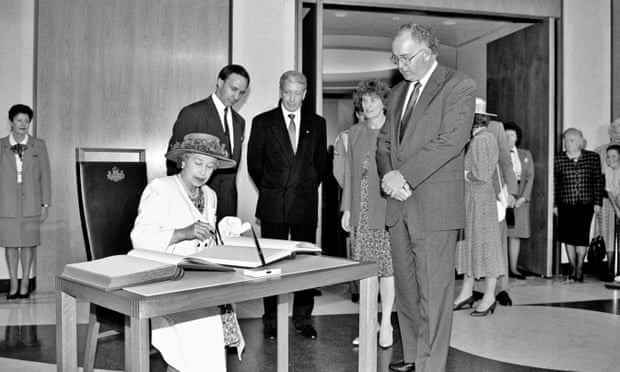Königin Elizabeth II. trägt sich im Februar 1992 im Parlamentsgebäude in Canberra in das Gästebuch ein, während Premierminister Paul Keating und Beamte zusehen.