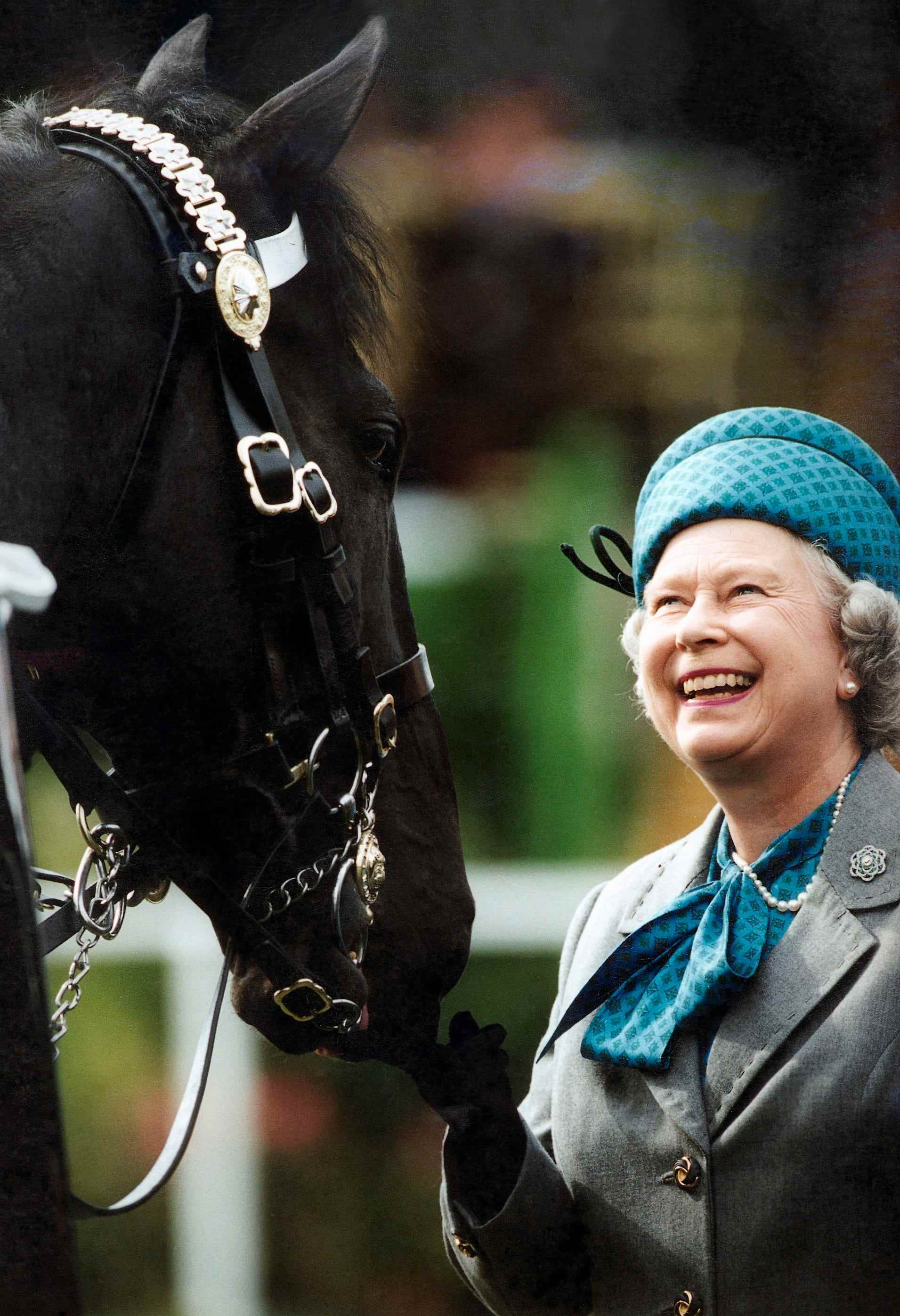 WINDSOR, VEREINIGTES KÖNIGREICH - 17. MAI: Königin Elizabeth Ll lächelt, während sie die auf Pferden montierten Truppen bei der Royal Windsor Horse Show überprüft.