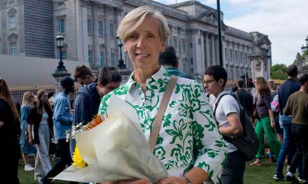 Julie Sanders hält Blumen vor dem Buckingham Palace